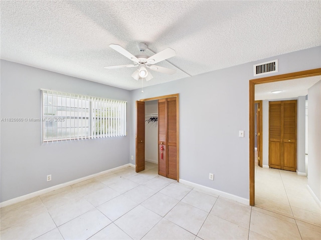 4113 NW 88th Ave Unit 105, Coral Springs, FL 33065 - unfurnished bedroom featuring a closet, light tile patterned floors, ceiling fan, and a textured ceiling