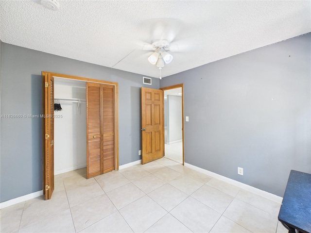 4113 NW 88th Ave Unit 105, Coral Springs, FL 33065 - unfurnished bedroom featuring a closet, a textured ceiling, a ceiling fan, and light tile patterned floors