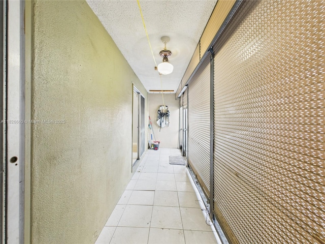 4113 NW 88th Ave Unit 105, Coral Springs, FL 33065 - hallway with a textured wall, a textured ceiling, and light tile patterned floors