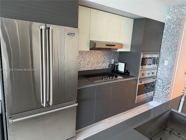 9821 E Bay Harbor Dr Unit 903, Bay Harbor Islands, FL 33154 - kitchen featuring stainless steel appliances, under cabinet range hood, modern cabinets, and tasteful backsplash