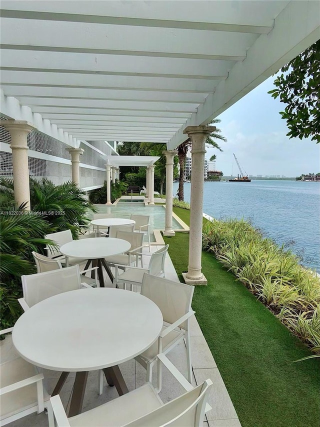 9821 E Bay Harbor Dr Unit 903, Bay Harbor Islands, FL 33154 - view of patio featuring outdoor dining space, a pergola, and a water view