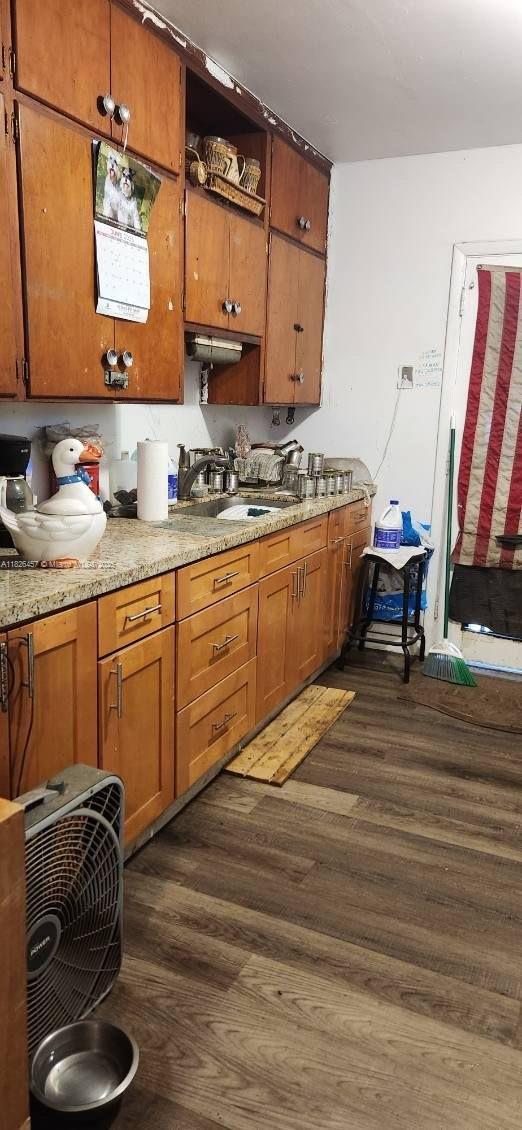 890 E 52nd St, Hialeah, FL 33013 - kitchen featuring dark wood-type flooring, brown cabinets, light countertops, and open shelves