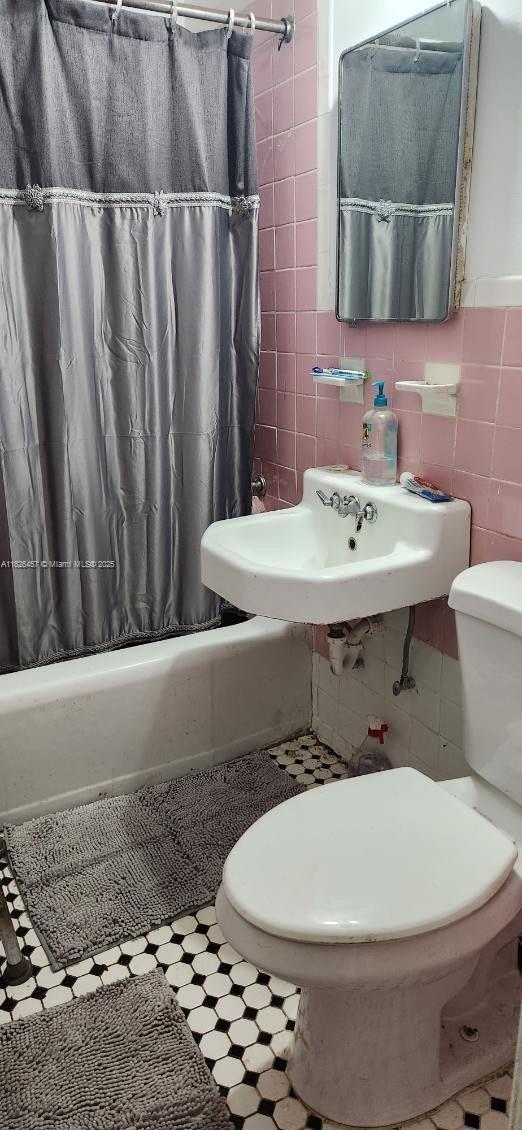 890 E 52nd St, Hialeah, FL 33013 - bathroom featuring tile walls and shower / tub combo with curtain