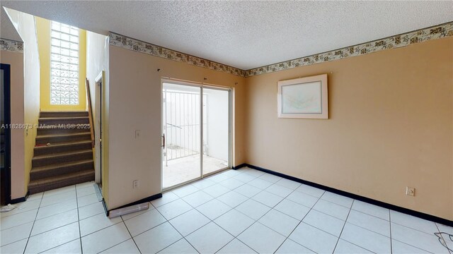 5130 Elmhurst Rd Unit H, West Palm Beach, FL 33417 - spare room featuring a textured ceiling and stairway