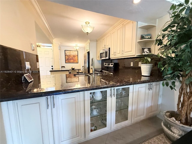 6404 Coral Lake Dr Unit 104, Margate, FL 33063 - kitchen with stainless steel appliances, a peninsula, backsplash, dark stone counters, and crown molding