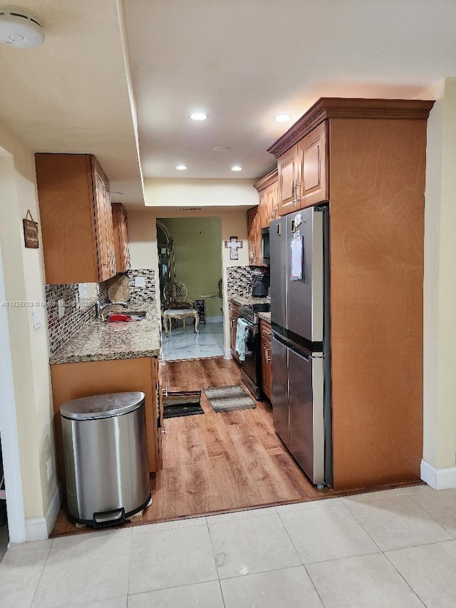 6311 NW 71st Ave, Tamarac, FL 33321 - kitchen featuring appliances with stainless steel finishes, backsplash, recessed lighting, light stone countertops, and brown cabinets