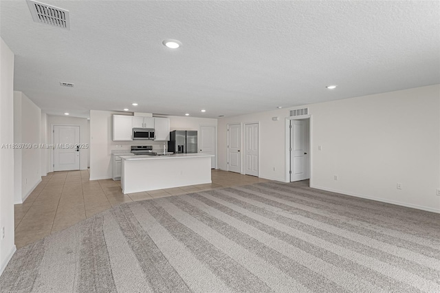 1230 Waterford, Palm Bay, FL 32909 - kitchen with stainless steel appliances, open floor plan, recessed lighting, white cabinetry, and a textured ceiling