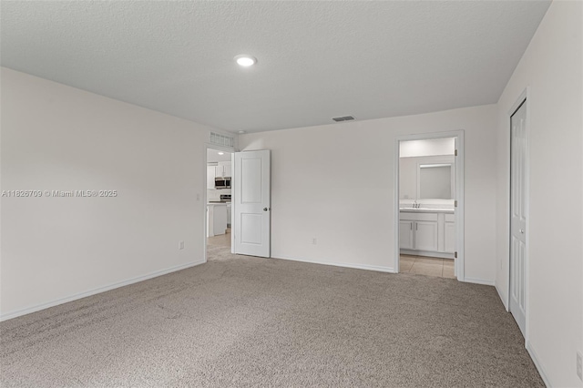 1230 Waterford, Palm Bay, FL 32909 - unfurnished bedroom featuring light colored carpet, connected bathroom, a closet, and a textured ceiling