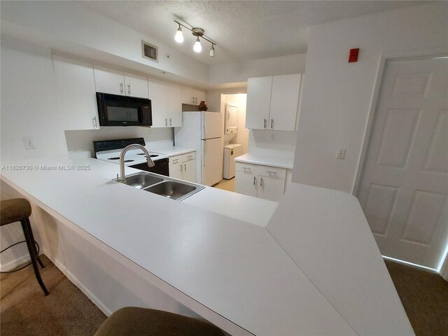 2640 S University Dr Unit 125, Davie, FL 33328 - kitchen featuring black microwave, freestanding refrigerator, range, light countertops, and a peninsula