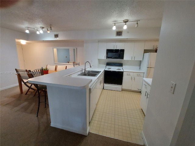 2640 S University Dr Unit 125, Davie, FL 33328 - kitchen featuring white appliances, a peninsula, a textured ceiling, track lighting, and light countertops