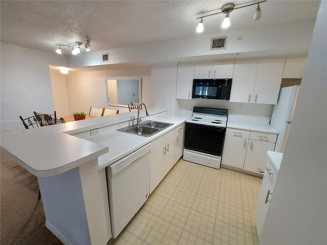 2640 S University Dr Unit 125, Davie, FL 33328 - kitchen featuring white appliances, rail lighting, a peninsula, light countertops, and white cabinetry