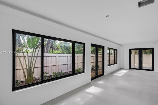 220 NE 105th St, Miami Shores, FL 33138 - empty room with french doors and finished concrete flooring