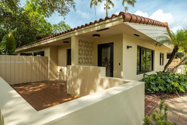 220 NE 105th St, Miami Shores, FL 33138 - doorway to property with stucco siding and a tile roof