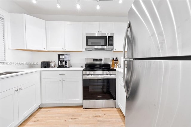 9481 Evergreen Pl Unit 206, Davie, FL 33324 - kitchen featuring appliances with stainless steel finishes, light countertops, white cabinets, and light wood-type flooring