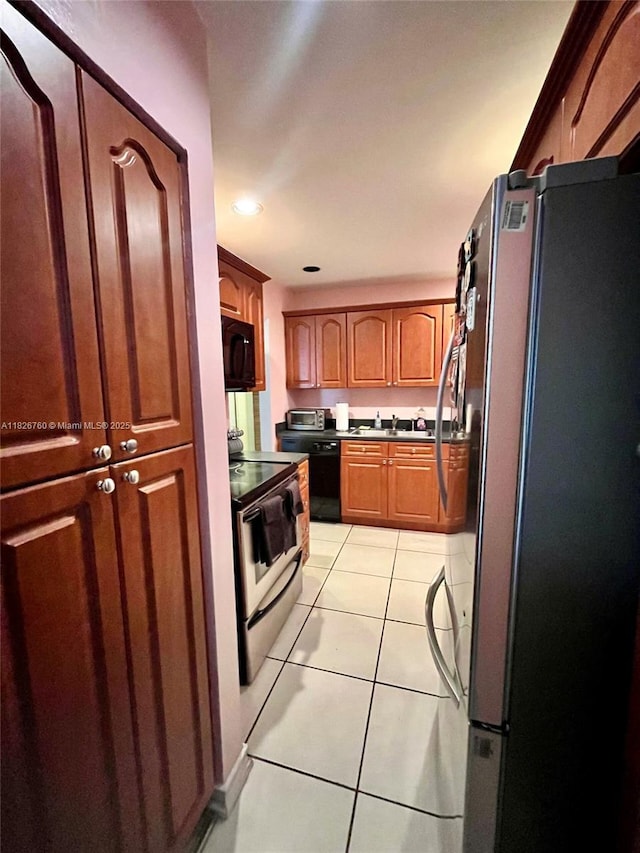 8325 SW 72nd Ave Unit 214C, Miami, FL 33143 - kitchen featuring black appliances, light tile patterned floors, brown cabinetry, and recessed lighting