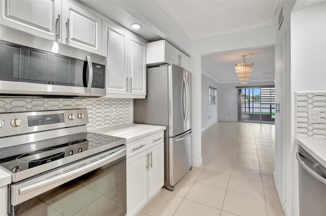 13800 SW 5th Ct Unit 101M, Pembroke Pines, FL 33027 - kitchen with stainless steel appliances, ornamental molding, a chandelier, white cabinets, and decorative backsplash