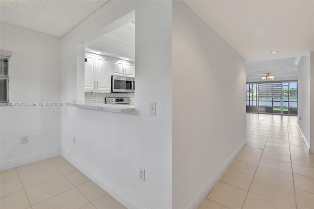 13800 SW 5th Ct Unit 101M, Pembroke Pines, FL 33027 - kitchen with appliances with stainless steel finishes, light tile patterned floors, white cabinetry, decorative backsplash, and recessed lighting