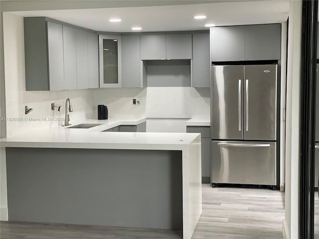 671 NE 195th St Unit 228E, Miami, FL 33179 - kitchen featuring gray cabinets, freestanding refrigerator, light wood finished floors, a peninsula, and recessed lighting
