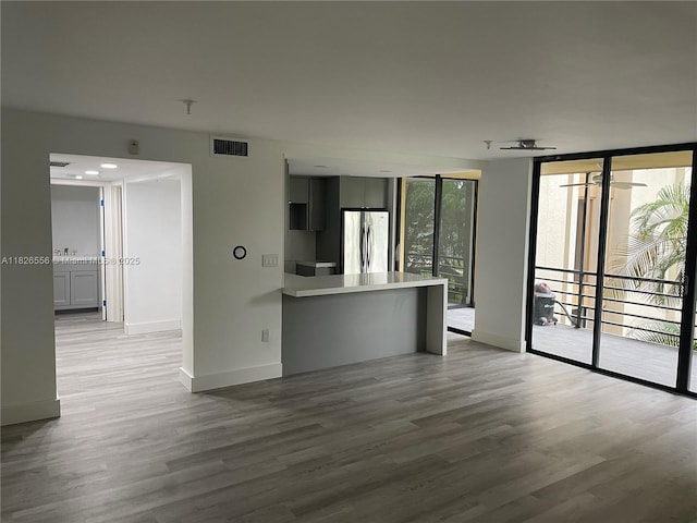 671 NE 195th St Unit 228E, Miami, FL 33179 - unfurnished living room featuring wood finished floors, floor to ceiling windows, and ceiling fan