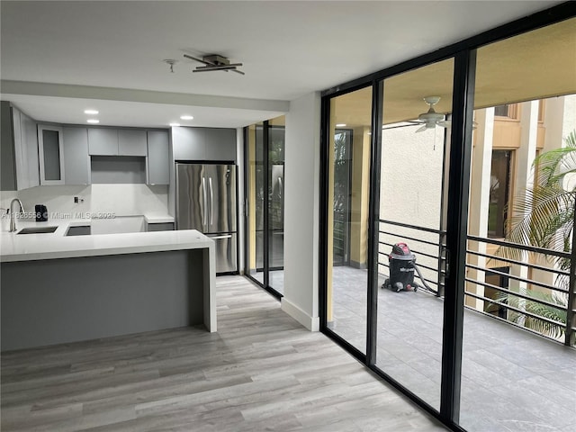 671 NE 195th St Unit 228E, Miami, FL 33179 - kitchen featuring freestanding refrigerator, gray cabinetry, expansive windows, plenty of natural light, and light wood-style floors