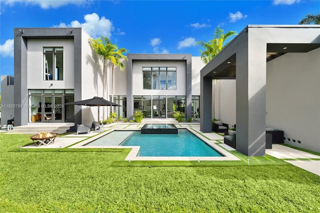 1009 NE 104th St, Miami Shores, FL 33138 - back of house with a fire pit, a lawn, a patio area, stucco siding, and a pool with connected hot tub