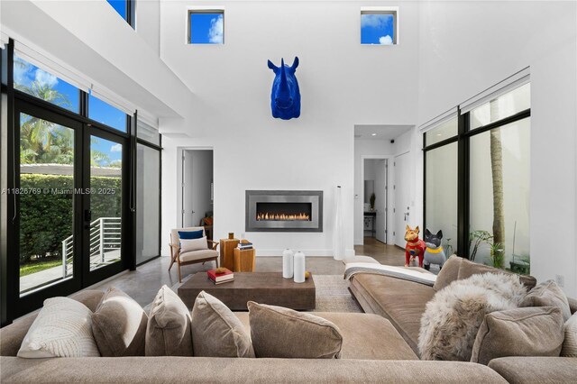 1009 NE 104th St, Miami Shores, FL 33138 - living area featuring a high ceiling, a warm lit fireplace, and french doors