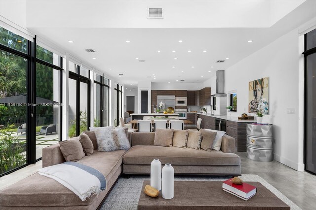 1009 NE 104th St, Miami Shores, FL 33138 - living area with finished concrete floors, recessed lighting, and a high ceiling