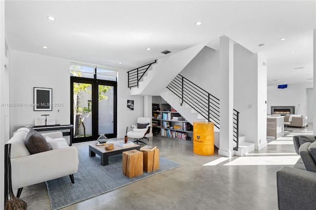 1009 NE 104th St, Miami Shores, FL 33138 - living room featuring stairs, finished concrete floors, recessed lighting, and a warm lit fireplace
