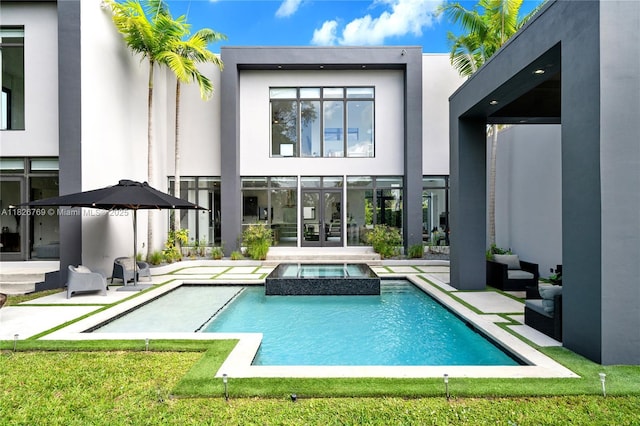 1009 NE 104th St, Miami Shores, FL 33138 - back of property with a pool with connected hot tub, a patio area, and stucco siding