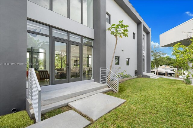 1009 NE 104th St, Miami Shores, FL 33138 - doorway to property featuring a yard and stucco siding