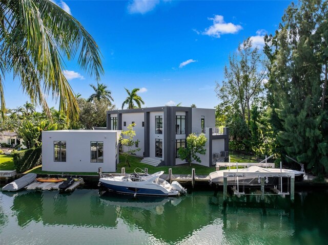 1009 NE 104th St, Miami Shores, FL 33138 - rear view of property with stucco siding, a yard, a water view, and boat lift
