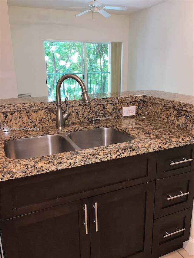 6001 SW 70th St Unit 324, South Miami, FL 33143 - kitchen view of a ceiling fan, light stone countertops, and dark brown cabinets
