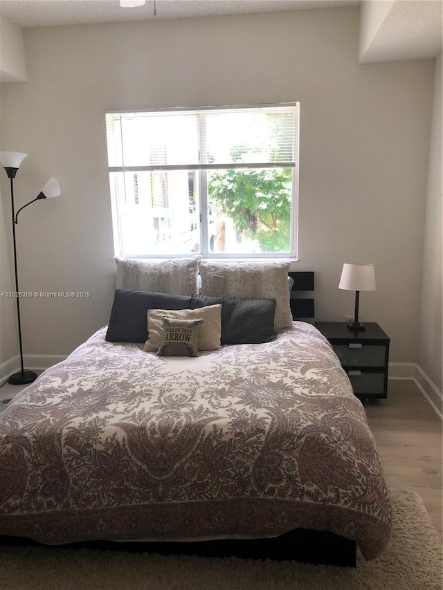 6001 SW 70th St Unit 324, South Miami, FL 33143 - bedroom featuring baseboards and wood finished floors