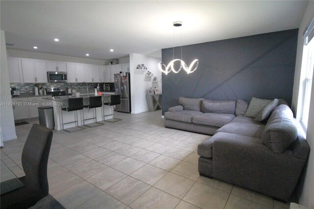 2574 SW Cameo Blvd, Port St Lucie, FL 34953 - living room featuring light tile patterned floors, a chandelier, and recessed lighting