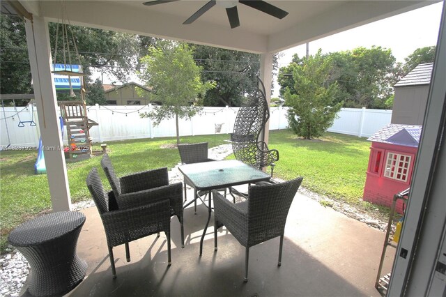 2574 SW Cameo Blvd, Port St Lucie, FL 34953 - fenced backyard featuring a ceiling fan, outdoor dining space, a patio, and a playground