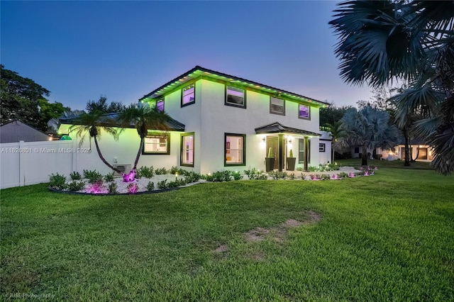 12220 Tara Dr, Plantation, FL 33325 - back of property at dusk with stucco siding and a yard