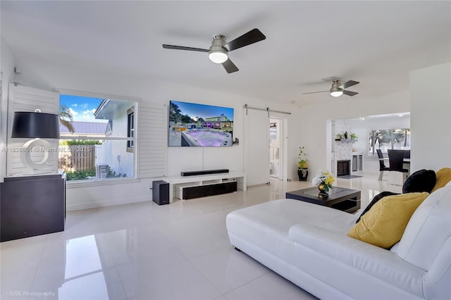 12220 Tara Dr, Plantation, FL 33325 - living area featuring ceiling fan, a barn door, healthy amount of natural light, and tile patterned flooring
