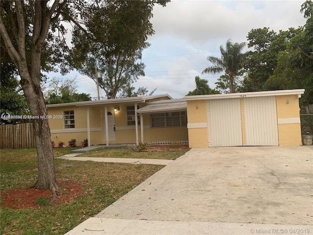 1624 NE 48th Ct, Pompano Beach, FL 33064 - view of front of house featuring concrete driveway, stucco siding, and a garage