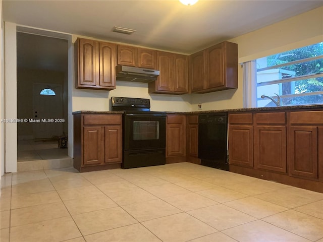 1624 NE 48th Ct, Pompano Beach, FL 33064 - kitchen with black appliances, under cabinet range hood, and light tile patterned floors