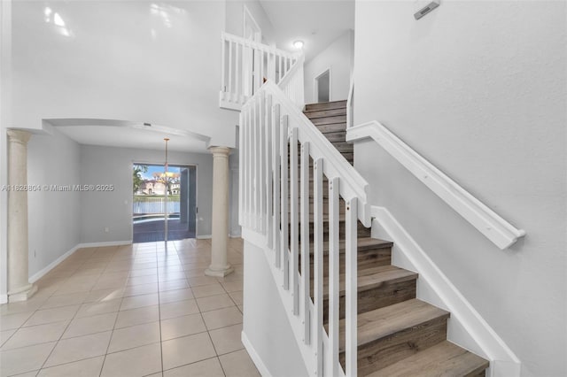 6425 SW 164th Ave, Miami, FL 33193 - staircase featuring decorative columns, arched walkways, tile patterned floors, and a high ceiling