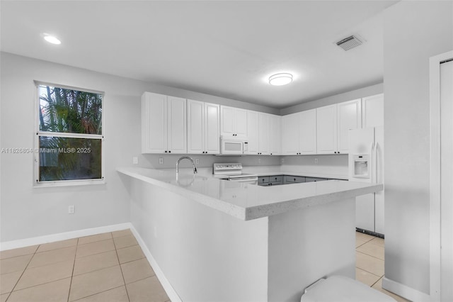 6425 SW 164th Ave, Miami, FL 33193 - kitchen with white appliances, light tile patterned floors, light countertops, a peninsula, and white cabinets