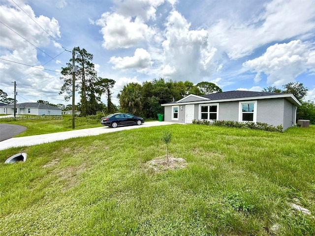 5029 N Dogwood Cir, La Belle, FL 33935 - view of front facade with stucco siding, driveway, and a front lawn