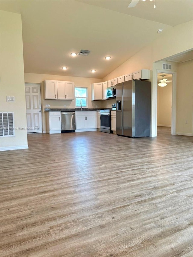 5029 N Dogwood Cir, La Belle, FL 33935 - kitchen featuring appliances with stainless steel finishes, dark countertops, a ceiling fan, light wood-style flooring, and vaulted ceiling
