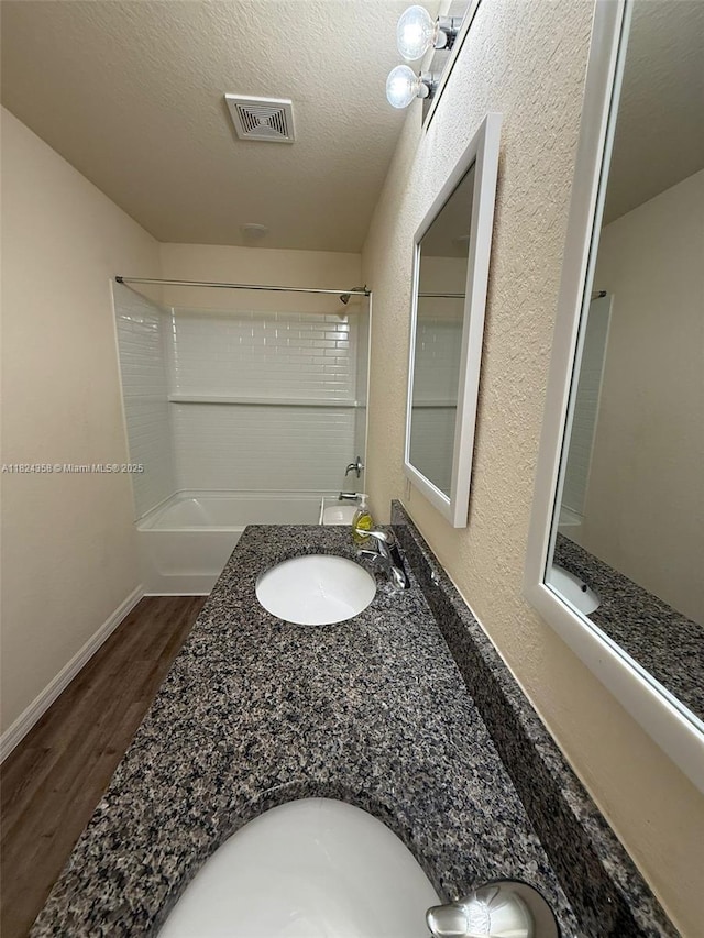 5029 N Dogwood Cir, La Belle, FL 33935 - full bath with wood finished floors, double vanity, tub / shower combination, and a textured ceiling