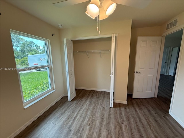 5029 N Dogwood Cir, La Belle, FL 33935 - unfurnished bedroom with wood finished floors, multiple windows, a closet, and a ceiling fan