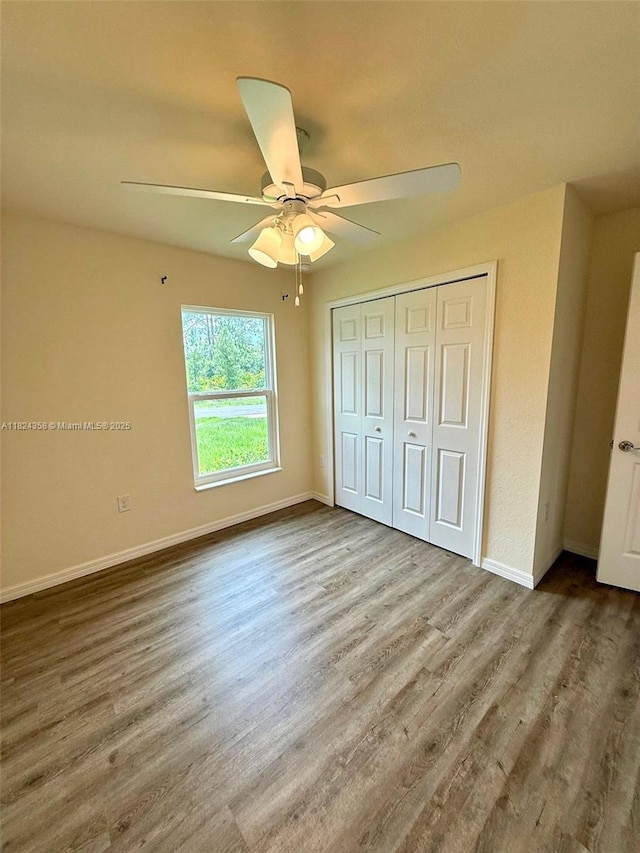 5029 N Dogwood Cir, La Belle, FL 33935 - unfurnished bedroom featuring wood finished floors, a closet, and a ceiling fan