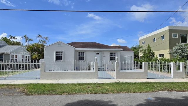 3640 SW 13th St, Miami, FL 33145 - bungalow with stucco siding, a fenced front yard, and a gate