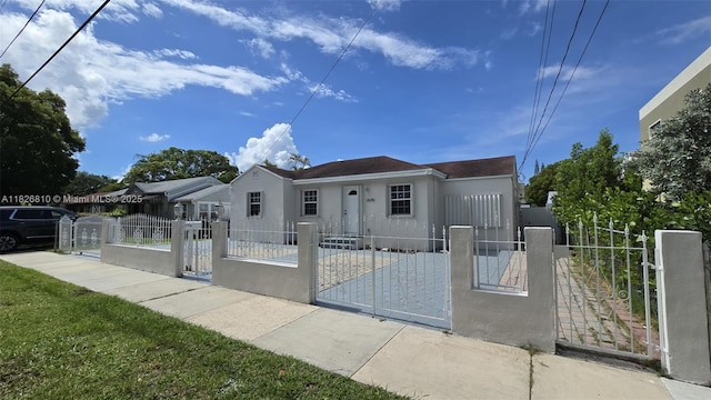 3640 SW 13th St, Miami, FL 33145 - view of front of home with stucco siding, a gate, and a fenced front yard
