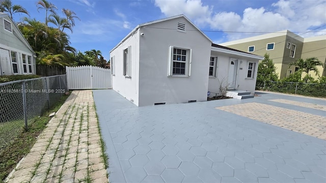 3640 SW 13th St, Miami, FL 33145 - view of front of home with stucco siding, a patio, and a gate