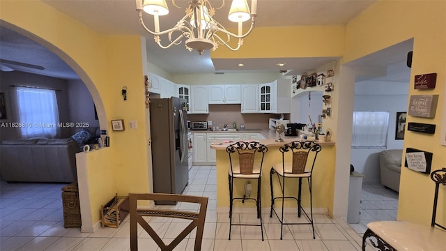 3640 SW 13th St, Miami, FL 33145 - kitchen with stainless steel fridge with ice dispenser, a peninsula, glass insert cabinets, a kitchen breakfast bar, and open floor plan